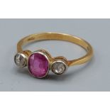 An 18ct gold ruby and diamond ring with a central ruby flanked by two diamonds, 2.2gms, ring size M