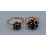 A 9ct gold garnet set cluster ring together with another similar 9ct gold garnet set cluster ring,