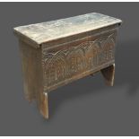 An early oak chip carved coffer, the hinged top above a carved front, 99cms wide, 40cms deep and