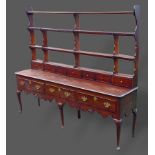 A George III oak dresser, the open shelf back with spice drawers above three drawers with brass