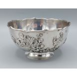 A Chinese white metal bowl decorated in relief with a foliate design, marks to base, 7ozs, 13cms