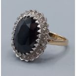 A 9ct gold sapphire and diamond cluster ring with a large oval sapphire surrounded by diamonds