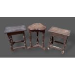 An oak joint stool with turned legs and stretchers together with another similar joint stool and a