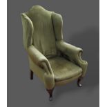 A late 19th Century wingback armchair with shaped arms and cabriole legs with pad feet, together