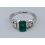 A ring set with a rectangular Emerald flanked by four baguette diamonds, 2gms, ring