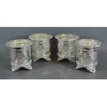 A set of four silver plated bottle stands of pierced from each with three low scroll feet, 12cms