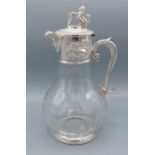 A silver plated and engraved glass claret jug, engraved with grape vine, the cover with Lion and