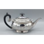 A George III silver teapot of half lobed form with shaped ebonised handle, London 1813, maker Samuel
