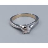 An 18ct white gold solitaire diamond ring, set with a single diamond within a crossover setting,