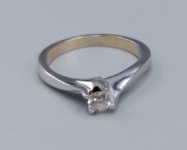 An 18ct white gold solitaire diamond ring, set with a single diamond within a crossover setting,