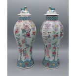 A pair of 19th Century Chinese porcelain Famille Rose covered vases of octagonal form decorated in