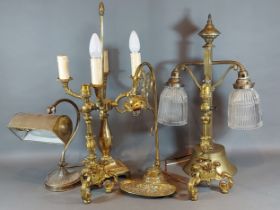 A brass and glass double table lamp together with a pair of brass table lamps and three other