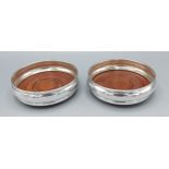 A pair Birmingham silver and turned wooden bottle coasters