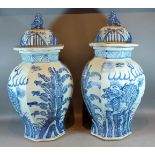 A pair of Chinese large under glaze blue decorated covered vases of octagonal form, decorated with