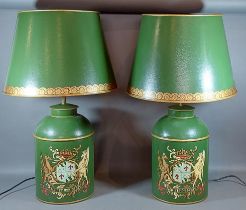 A pair of Toleware table lamps, each decorated with an armorial crest on a green ground and with