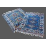 A Turkish woollen rug with an all-over design upon a terracotta, blue and cream ground together with