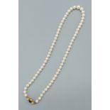 A graduated cultured pearl necklace, the 9ct gold clasp set with a central Amethyst flanked by