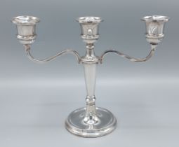 A Birmingham silver three branch candleabrum with shaped arms and circular base, 20cms tall