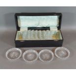 A set of twelve cut glass coasters within a fitted case