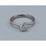 An 18ct gold solitaire diamond ring with crossover claw setting, approximately 0.35ct, ring size