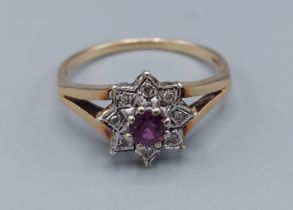 A 9ct gold cluster ring set with a central Amethyst surrounded by diamonds within a pierced setting,