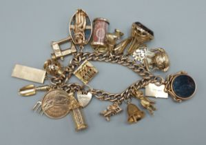 A 9ct gold charm bracelet set with many charms to include two fob seals and a padlock clasp, 99.4gms