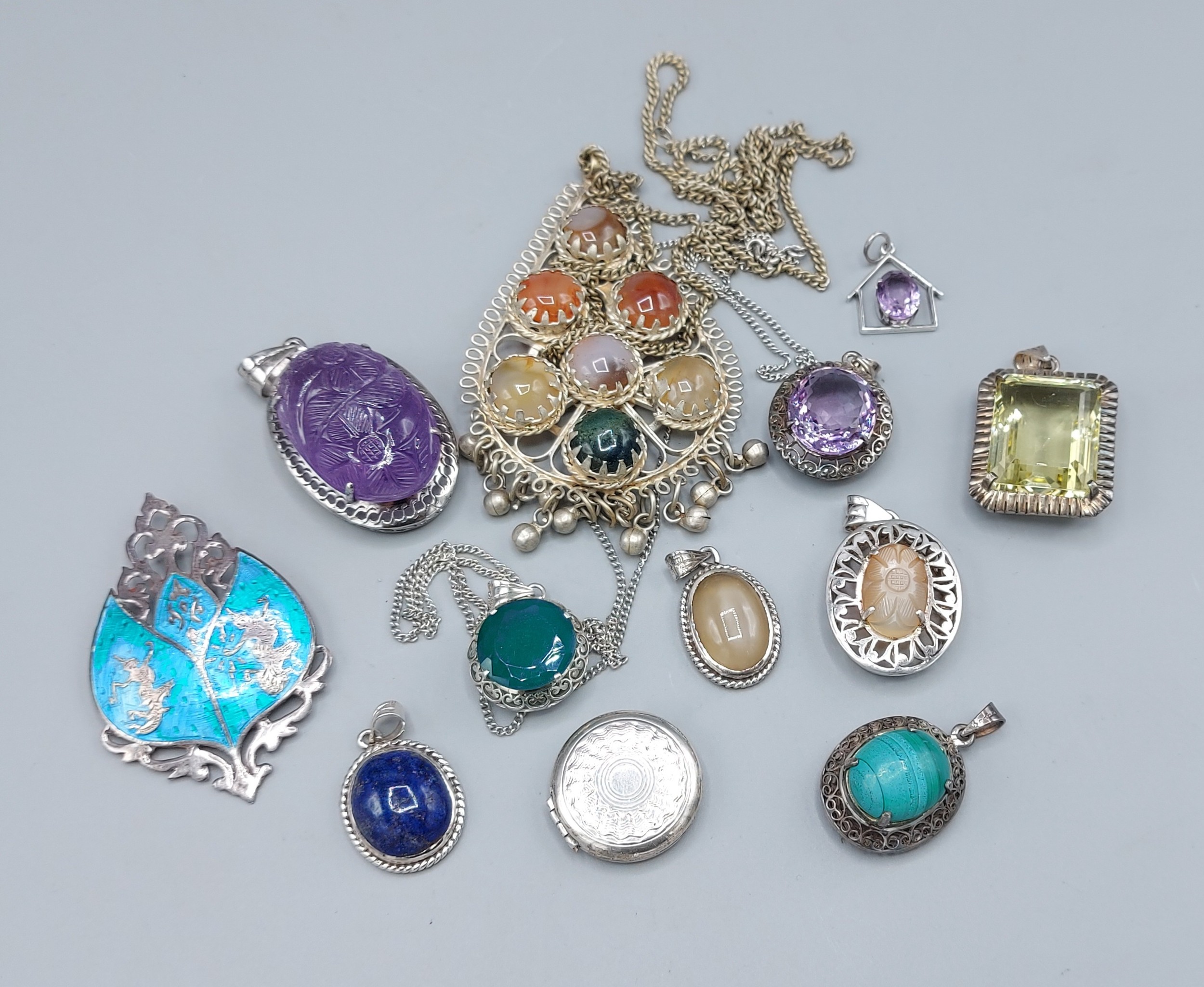 A collection of silver pendants and brooches set various stones