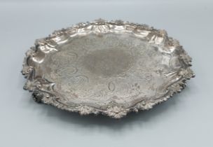 A Victorian silver salver of shaped outline with engraved decoration and three scroll feet, 20ozs,