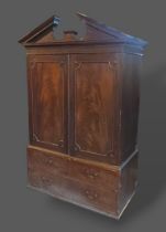 A 19th Century mahogany press cupboard, the moulded cornice above two panel doors enclosing