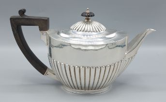 An Edwardian silver teapot of half lobed form with ebonised handle, London 1910, 19ozs