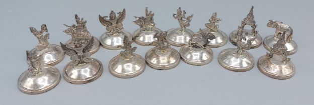 A set of fifteen sterling silver menu holders, decorated with figures and animals
