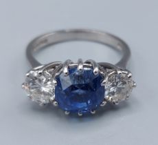 An 18ct white gold Sapphire and diamond ring, the central mid blue Sapphire approx. 4.92ct flanked