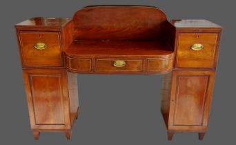 A Regency mahogany pedestal sideboard with a central drawer flanked by cupboards raised upon low