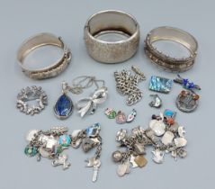 Three silver bangles together with a silver charm bracelet and various other silver jewellery