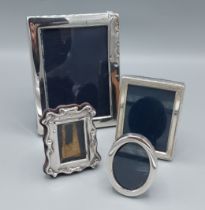 A rectangular silver photograph frame, 16cms x 12cms together with three small silver photograph