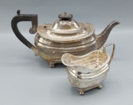 A George V silver teapot with ebonised handle, together with a matching cream jug, Sheffield 1917,