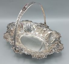 A Victorian silver fruit basket of embossed pierced form with swing handle, London 1900, makers