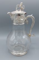 A silver plated and engraved glass claret jug, engraved with grape vine, the cover with Lion and