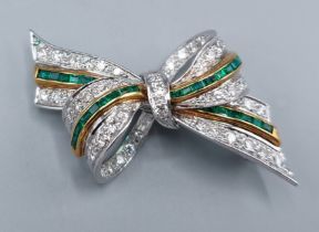 An 18ct gold brooch in the form of a bow set with two bands of Emeralds and four bands of