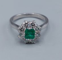 An 18ct white gold and Platinum Emerald and Diamond ring, the central Emerald approx. 0.50ct