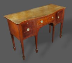 A 19th Century mahogany serpentine sideboard with a central drawer flanked by cupboard doors with
