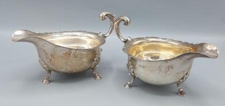 A pair of Sheffield silver sauce jugs, with shaped handles and raised upon hoof supports, by