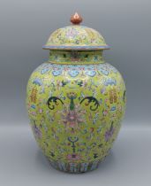 A Qianlong covered vase, decorated in polychrome enamels upon a yellow ground, seal mark to base,