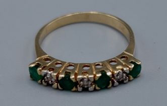 A 14ct gold Emerald and Diamond ring, set with four Emeralds and three Diamonds within a pierced