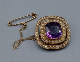 A 9ct gold brooch set with a central Amethyst surrounded with two bands of pearls, 3gms