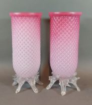 A pair of early 20th Century pink glass storm vases with naturalistic clear glass bases, 24cms tall