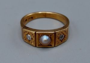 An 18ct gold ring set with a central pearl flanked by two diamonds, 5.6gms, ring size N