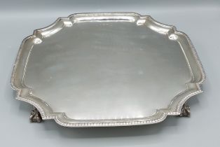 A Sheffield silver salver of shaped outline with four ball claw feet, 38ozs, 34cms square