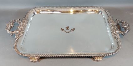A 19th Century silver plated large two handled tray, with a central crest and four scroll feet,
