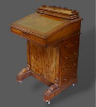 A Victorian walnut Davenport, the stationary compartment above a writing surface with four side